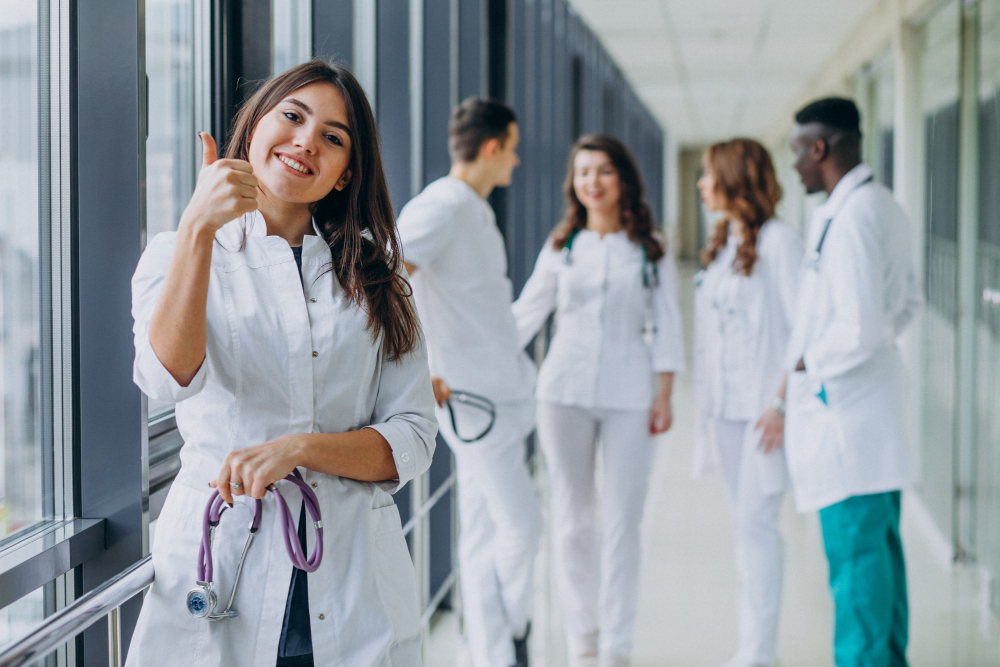 young-female-doctor-with-thumbs-up-gesture-standing-in-the-corridor-of-the-hospital